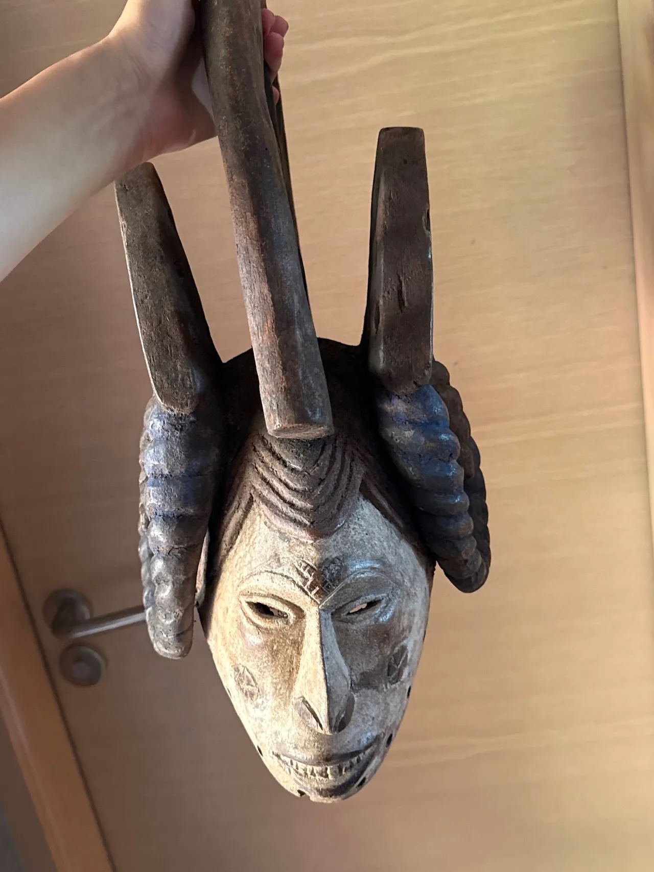 Carved Wooden Crested and Horned Mask with Central Handle
