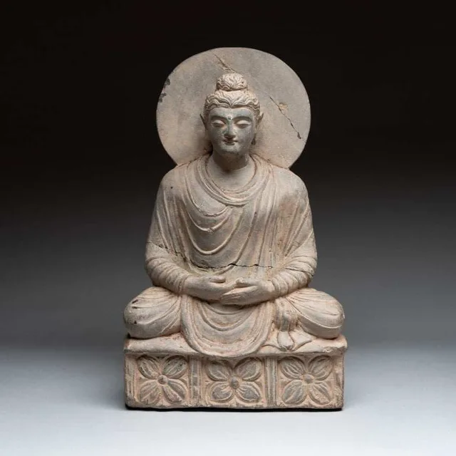 Gandhara grey schist sculpture of a seated Buddha with a nimbus